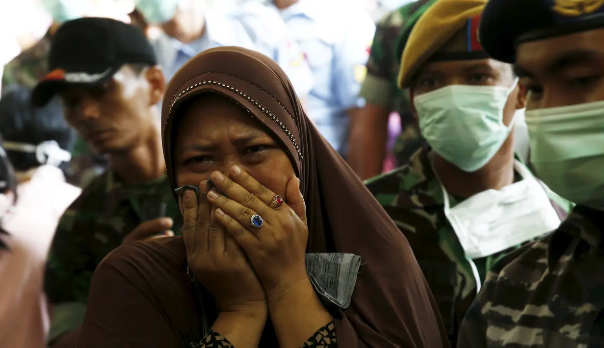 Seorang ibu menangisi anaknya yang menjadi korban dari jatuhnya pesawat Hercules C-130 di Medan, Rabu (1/7/2015). Peristiwa ini menambah catatan kecelakaan yang disebabkan tuanya alustista yang digunakan TNI. (REUTERS/Beawiharta)