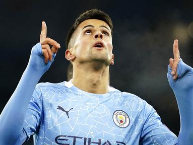 Bek Manchester City, Joao Cancelo, melakukan selebrasi usai mencetak gol ke gawang Olympiakos pada laga Liga Champions di Stadion Etihad, Rabu (4/11/2020). Manchester City menang dengan skor 3-0. (AP/Dave Thompson)