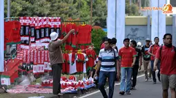 Di antara segelintir suporter, masih ada pedagang yang mengadu nasib menjajakan beragam aksesoris Timnas Indonesia di Stadion GBK Jakarta saat kualifikasi Piala AFC U19 Grup G (Liputan6.com/Helmi Fithriansyah)