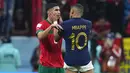 <p>Pemain Prancis, Kylian Mbappe (kanan) menghibur pemain Maroko, Achraf Hakimi setelah laga semifinal Piala Dunia 2022 yang berlangsung di Al Bayt Stadium, Qatar, Rabu (14/12/2022) waktu setempat. (AP Photo/Manu Fernandez)</p>