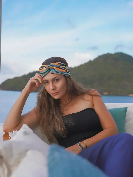 Menikmati alam, lihat gaya slay Wulan Guritno dengan busana kasual yang slay. Atasan tanpa taliberwarna hitam dipadunya dengan celana kain santai berwarna biru. [Foto: Instagram/wulanguritno]