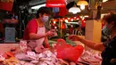 Seorang penjual dan pelanggan memakai masker di pasar lokal di Hong Kong, Rabu (22/7/2020). Hong Kong telah mewajibkan penggunaan masker di semua area publik tertutup termasuk mal dan pasar seiring penambahan kasus baru harian Covid-19. (AP Photo/Kin Cheung)