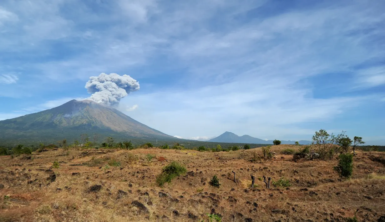 Gunung Agung mengeluarkan asap bercampur abu vulkanis terlihat dari desa Tulamben, Karangasem, Bali, Selasa (3/7). Walau terus mengalami letusan hampir sepekan terakhir, Gunung Agung masih berada pada status level III (siaga). (AFP/SONNY TUMBELAKA)