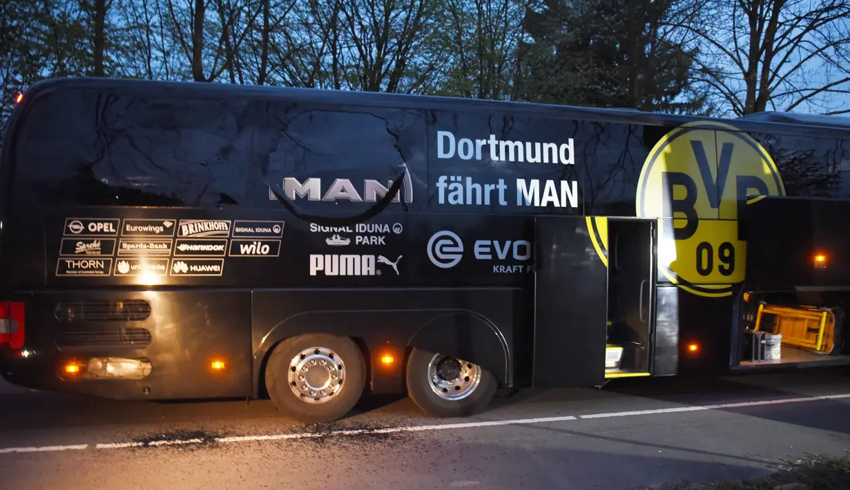 Kendaraan polisi terparkir di depan bus tim Borussia Dortmund yang rusak terkena ledakan di Dortmund, Jerman Barat, Selasa (11/4). Bus membawa pemain Borussia Dortmund untuk pertandingan perempat final Liga Champions melawan Monaco. (Patrik STOLLARZ/AFP)