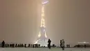 Suasana malam Menara Eiffel saat hujan salju di Paris Prancis (6/2). Ratusan orang terpaksa meninggalkan mobil mereka untuk tidur di tempat penampungan darurat akibat cuaca ekstrem yang melanda. (AFP Photo / Philippe Dupeyrat)