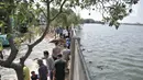 Pekerja menyelesaikan perbaikan tanggul jebol di Kompleks Perumahan Pantai Mutiara, Pluit, Jakarta, Minggu (7/6/2020). Tanggul jebol dengan panjang sekitar 10 meter yang terjadi bersamaan air pasang pada Sabtu (6/6) menyebabkan perumahan tersebut terendam banjir rob. (Liputan6.com/Iqbal S. Nugroho)