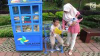 Seorang ibu menemani anaknya membaca buku yang tersedia di layanan Kotak Literasi Cerdas (Kolecer) di Taman Sempur, Bogor, Jawa Barat, Kamis (20/12). Kehadiran Kolecer bertujuan untuk menumbuhkan budaya literasi. (Merdeka.com/Arie Basuki)