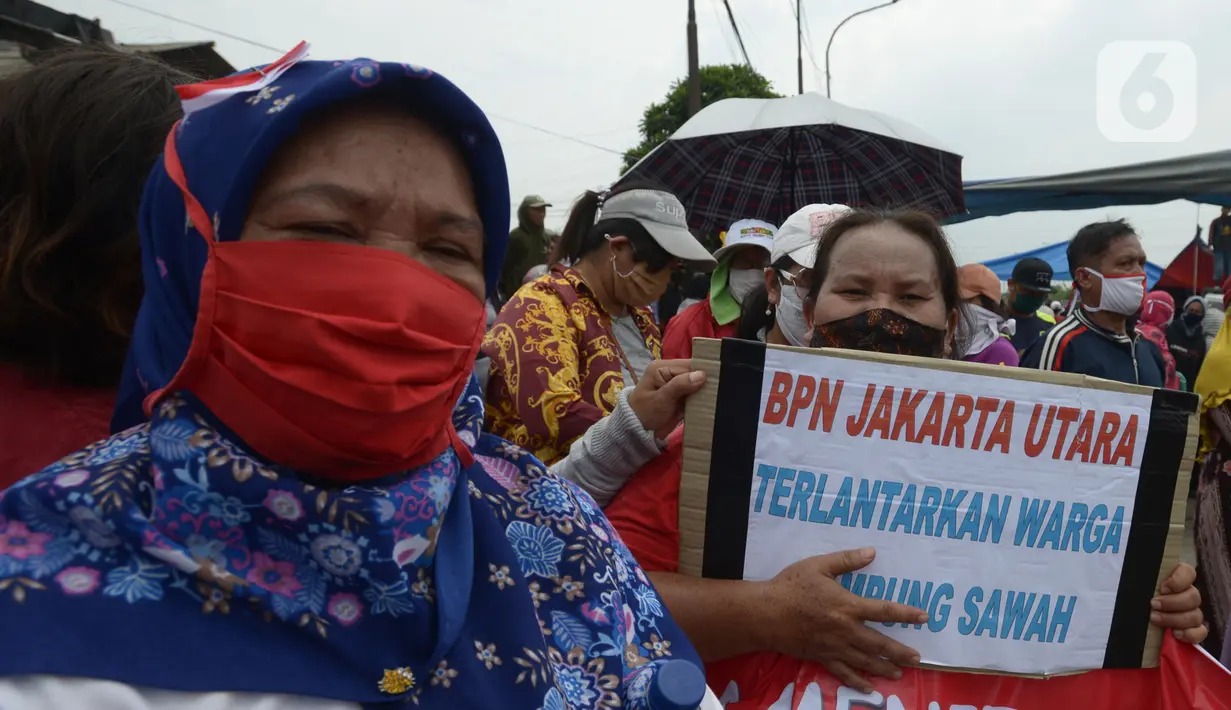 Warga Kampung Sawah melakukan aksi dengan menutup akses jalan Cakung Cilincing, Jakarta, Rabu (18/11/2020). Aksi tutup jalan ini merupakan sebagai bentuk protes warga atas hak tanahnya yang terkena proyek pembangunan jalan tol Cakung Cilincing (Cacing)-Cibitung. (merdeka.com/Imam Buhori)
