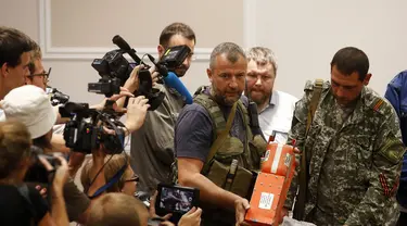 Salah satu anggota kelompok separatis pro-Rusia menunjukkan kotak hitam pesawat Malaysia Airlines MH-17 di Donetsk, (22/7/2014). (REUTERS/Maxim Zmeyev)