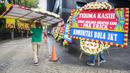 Sejumlah petugas membawa karangan bunga di kantor PSSI yang terletak di GBK Arena, Senayan, Jakarta, Kamis (30/03/2023) sebagai respon pembatalan Indonesia sebagai tuan rumah Piala Dunia U-20 2023 oleh FIFA. (Bola.com/Bagaskara Lazuardi)