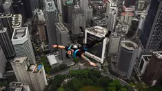 Penerjun Australia Chris Mcdougall melompat dari dek terbuka Menara Kuala Lumpur saat International Tower Jump, Kuala Lumpur, Malaysia, 3 Februari 2023. Lebih dari 100 penerjun melompat dari Menara Kuala Lumpur setinggi 300 meter yang terkenal tersebut. (MOHD RASFAN/AFP)