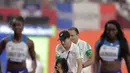 Sprinter Amerika Serikat, English Gardner menutupi wajahnya saat dibawa oleh tim medis akibat cedera dalam semifinal 100 meter putri Kejuaraan Atletik Dunia di Doha, Qatar, Minggu (29/9/2019). Peraih medali emas olimpiade tersebut mengalami cedera hamstring. (AP Photo/Petr David Josek)