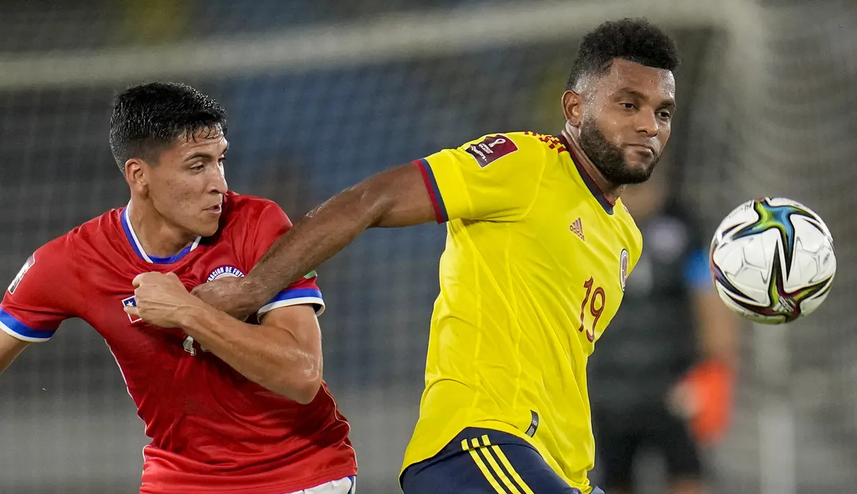 Gelandang Chile Macelino Nunez dan penyerang Kolombia Miguel Borja berebut bola pada lanjutan Kualifikasi Piala Dunia 2022 zona Amerika Selatan di Estadio Metropolitano Roberto Meléndez, Jumat (10/9/2021). Dua gol Miguel Borja memastikan Kolombia menang 3-1 atas Chile.  (AP/Fernando Vergara)