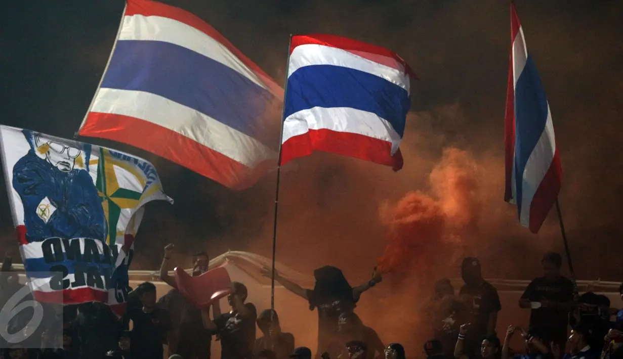 Suporter Timnas Thailand menyalakan suar saat menyambut kemenangan timnya atas Indonesia di National Stadium Rajamangala, Bangkok, Sabtu (17/12). Thailand berhasil meraih piala AFF untuk yang kelima kali. (Liputan6.com/Helmi Fithriansyah)