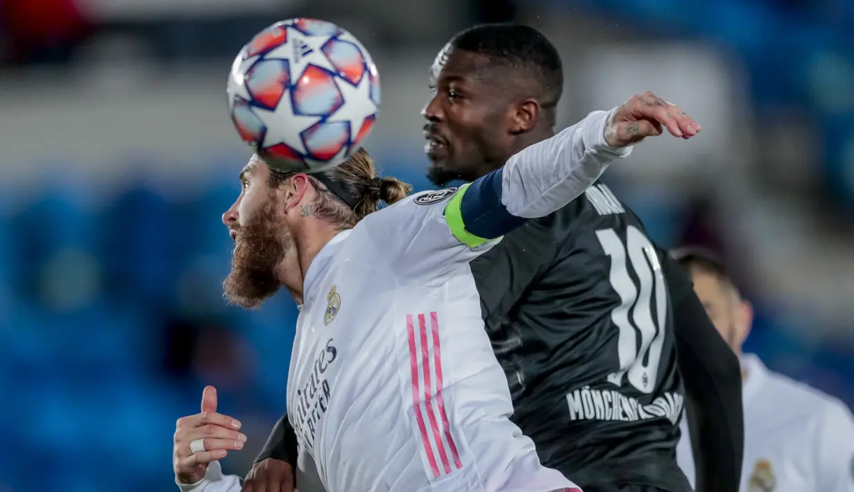 Bek Real Madrid, Sergio Ramos berebut bola dengan pemain Borussia Monchengladbach, Marcus Thuram pada pertandingan Grup B Liga Champions di Estadio Alfredo Di Stefano, Kamis (10/12/2020). Kemenangan ini mengantar Madrid lolos ke babak 16 besar Liga Champions. (AP Photo/Bernat Armangue)