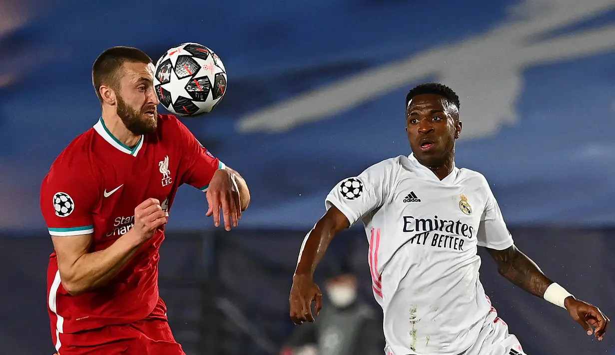Bek Liverpool, Nathaniel Phillips menantang penyerang Real Madrid, Vinicius Junior pada leg pertama perempatfinal Liga Champions di Estadio Alfredo Di Stefano, Rabu (7/4/2021) dini hari WIB. Real Madrid makin dekat ke semifinal Liga Champions usai menang 3-1 atas Liverpool. (GABRIEL BOUYS / AFP)