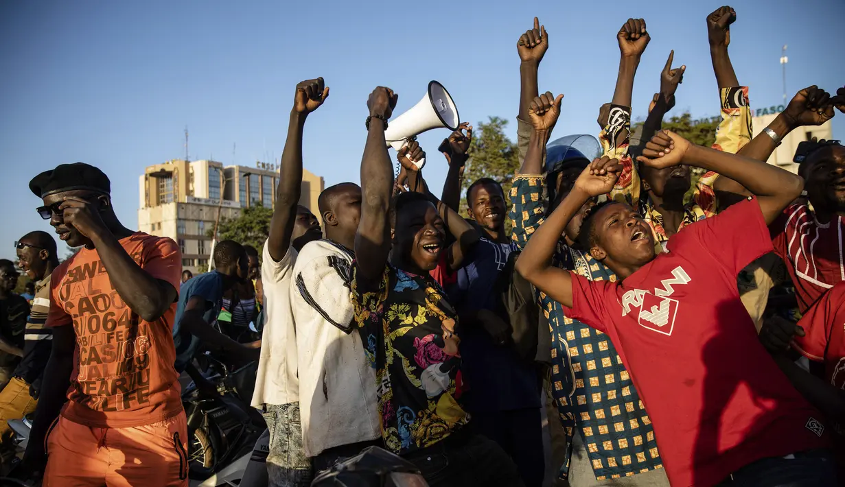 Kerumunan merayakan pengumuman bahwa Letnan Kolonel Paul Henri Sandaogo Damiba mengambil kendali negara di Ouagadougou, Burkina Faso, Senin (24/1/2022). Militer Burkina Faso mengklaim kudeta dilakukan tanpa kekerasan dan menyatakan mereka yang ditahan berada di lokasi yang aman. (AP/Sophie Garcia)