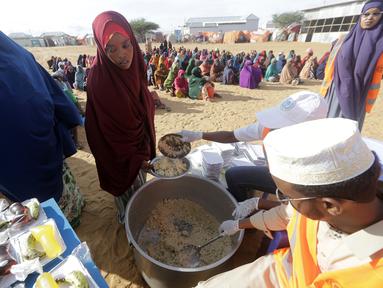 LSM lokal menyiapkan makanan berbuka puasa untuk orang-orang selaam bulan suci Ramadhan di kamp pengungsi internal di pinggiran Mogadishu, Somalia pada Jumat, 24 Maret 2023. (AP Photo/Farah Abdi Warsameh)