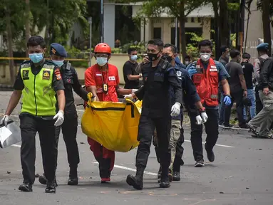 Polisi membawa tas berisi jenazah tersangka pelaku bom bunuh diri setelah ledakan di luar sebuah gereja di Makassar (28/3/2021). Kapolda Sulsel Irjen Merdisyam menduga, ledakan yang terjadi di Gereja Katedral Makassar diduga akibat bom bunuh diri. (AFP/Indra Abriyanto)