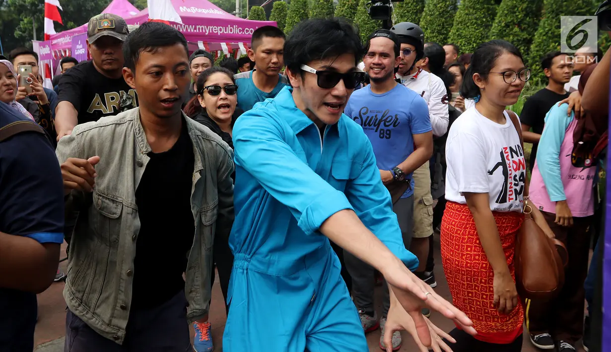 Aktor Vino G. Bastian usai membagikan kopi gratis kepada pengunjung CFD saat promo film Warkop DKI Reborn part 2 di Senayan, Jakarta, Minggu (13/08). Pemutaran film tersebut akan tayang perdana pada 31 Agustus mendatang. (Liputan6.com/Fery Pradolo)