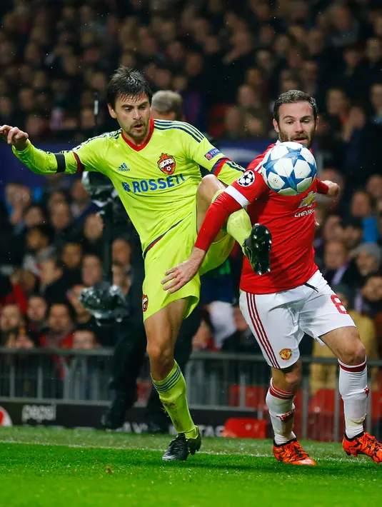 Gelandang MU, Juan Mata (kanan) berusaha merebut bola dari kawalan bek CSKA Moscow,  Georgy Shchennikov pada liga champions di stadion Old Trafford,Inggris (3/11). Manchester United menang atas CSKA Moscow dengan skor 1-0. (Reuters/Darren Staples)