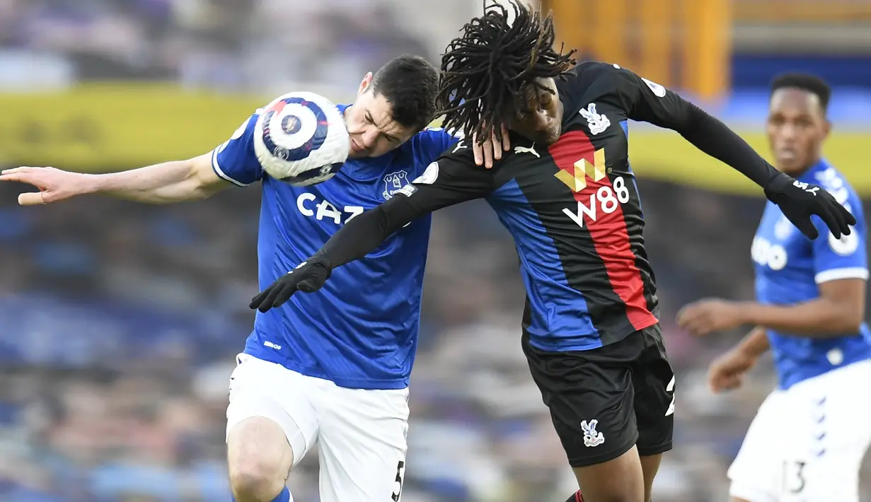 Bek Everton, Michael Keane dan gelandang Crystal Palace, Eberechi Eze bersaing memperebutkan bola pada pekan ke-30 Liga Inggris di Goodison Park, Selasa (6/4) dini hari WIB. Duel Everton vs Crystal Palace harus berakhir imbang dengan skor 1-1. (Peter Powell / Pool via AP)