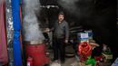 Seorang pekerja memasak chestnut di pasar di Beijing (20/11). (AFP Photo/Nicolas Asfouri)