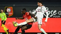 Striker Rennes, Jeremy Doku (kiri) berebut bola dengan gelandang Nice, Pierre Lees-Melou dalam laga lanjutan Liga Prancis 2020/21 pekan ke-27 di Roazhon Park Stadium, Rennes, Jumat, (26/2/2021). Rennes kalah 1-2 dari Nice. (AFP/Damien Meyer)