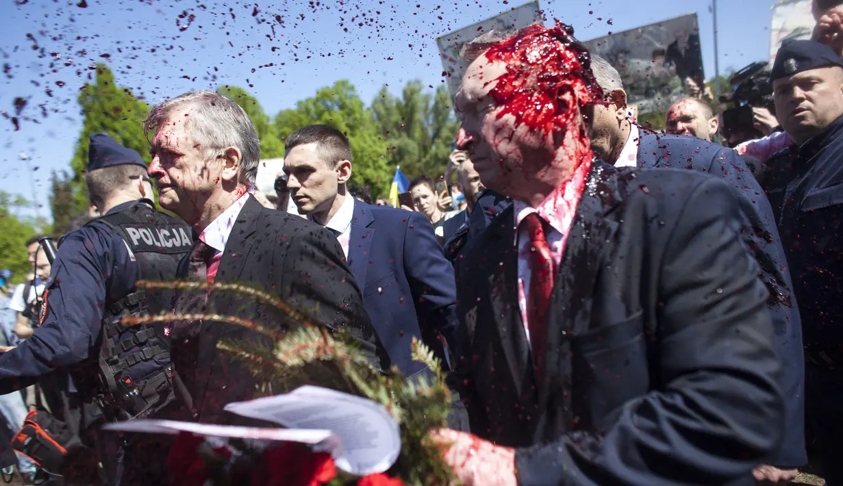 <p>Duta Besar Rusia untuk Polandia Sergei Andreev ditutupi dengan cat merah di Warsawa, Polandia, Senin (9/5/2022). Para pengunjuk rasa yang memprotes perang di Ukraina melemparkan cat merah pada duta besar Rusia tersebut ketika Sergei Andreev tiba di pemakaman untuk meletakkan karangan bunga memperingati Victory Day atau Hari Kemenangan. (AP Photo/Maciek Luczniewski)</p>
