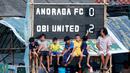 Sejumlah anak asik duduk di depan papan skor pertandingan tarkam di Lapangan Latus Jaya, Kedaung, Pamulang, Minggu (12/3/2023). (Bola.com/M Iqbal Ichsan)