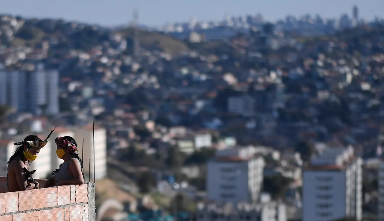 Anggota kelompok etnis Pataxo Hahahae mengenakan masker di Vila Vitoria favela di pinggiran Belo Horizonte, negara bagian Minas Gerais, Brasil, pada 8 Juli 2020 di tengah pandemi coronavirus novel COVID-19.  (AFP/Douglas Magno)