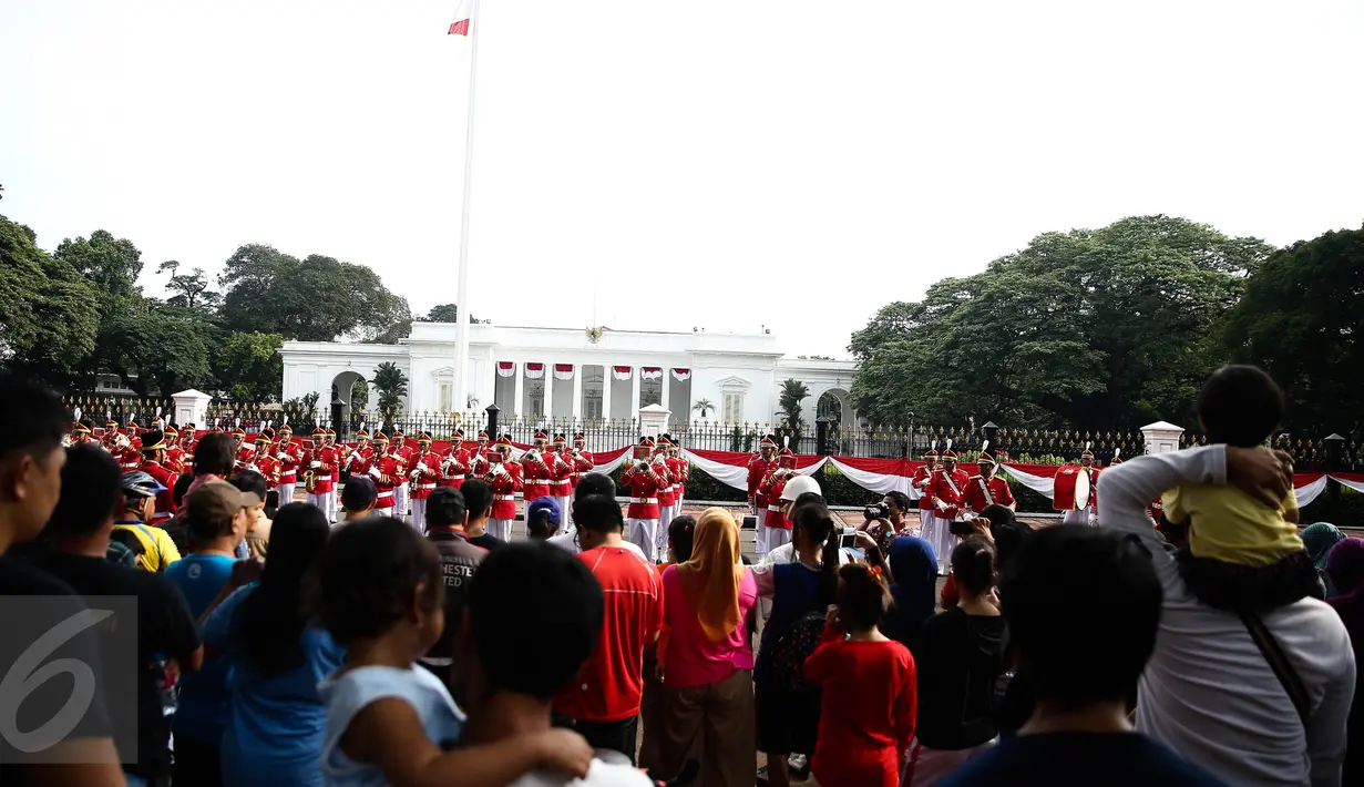 Antusias warga melihat anggota Paspampres melakukan prosesi pergantian jaga Istana Kepresiden di depan Istana Merdeka, Minggu (28/8). Ini merupakan pelaksanaan seremoni pergantian pasukan jaga istana untuk yang kedua kalinya (Liputan6.com/Faizal Fanani)