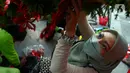 Seorang wanita menghias pohon Natal di Bundaran HI, Jakarta, Kamis (23/12/2021). Dalam rangka menyambut Natal 2021, Pemprov DKI Jakarta menggelar Christmas Carol mulai 21 hingga 23 Desember 2021. (merdeka.com/Imam Buhori)