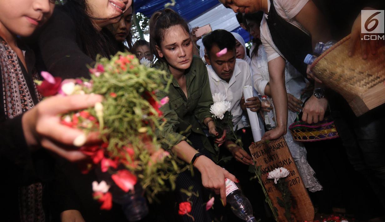Artis Luna Maya saat menaburkan bunga di atas makam Julia Perez di Taman Pemakaman Umum Pondok Ranggon, Cijantung, Jakarta Timur, Sabtu (10/6). Jupe menghembuskan napas terakhir di RSCM, pada Sabtu 10 Juni 2017. (Liputan6.com/Herman Zakharia)