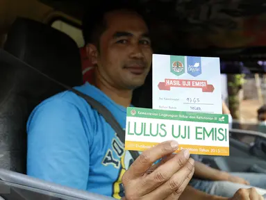 Pengedara menunjukan bukti tanda lulus uji emisi usai dilakukan pengujian emisi, Depok, (4/11/2015). Kemeterian Lingkungan Hidup dan Kehutanan RI gelar uji emisi kendaraan roda empat secara gratis di Jalan Juanda, Depok. (Liputan6.com/Yoppy Renato)
