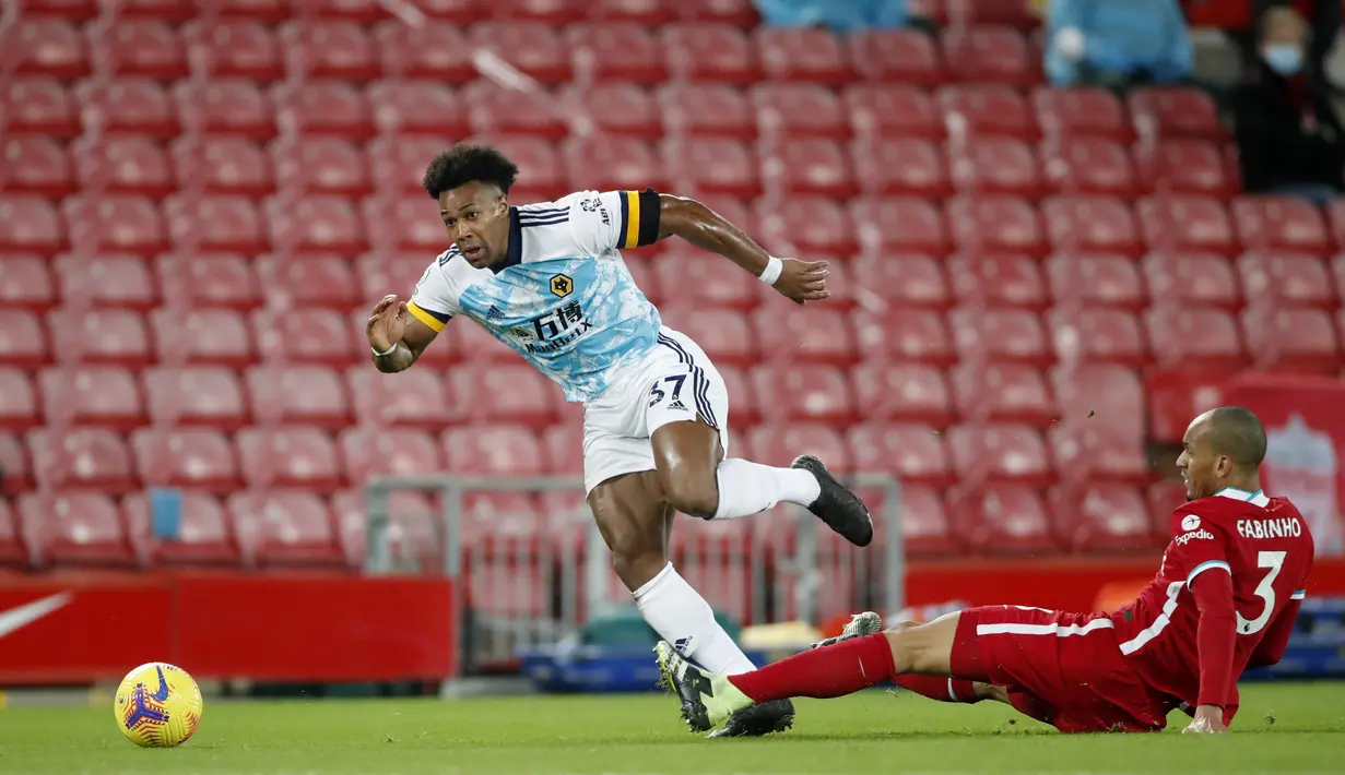 Penyerang Wolverhampton Wanderers, Adama Traore berusaha melewati gelandang Liverpool, Fabinho pada pertandingan lanjutan Liga Inggris di Stadion Anfield, Inggris, Minggu (7/12/2020).  Liverpool menang telak atas Wolverhampton 4-0. (Clive Brunskill/Pool via AP)