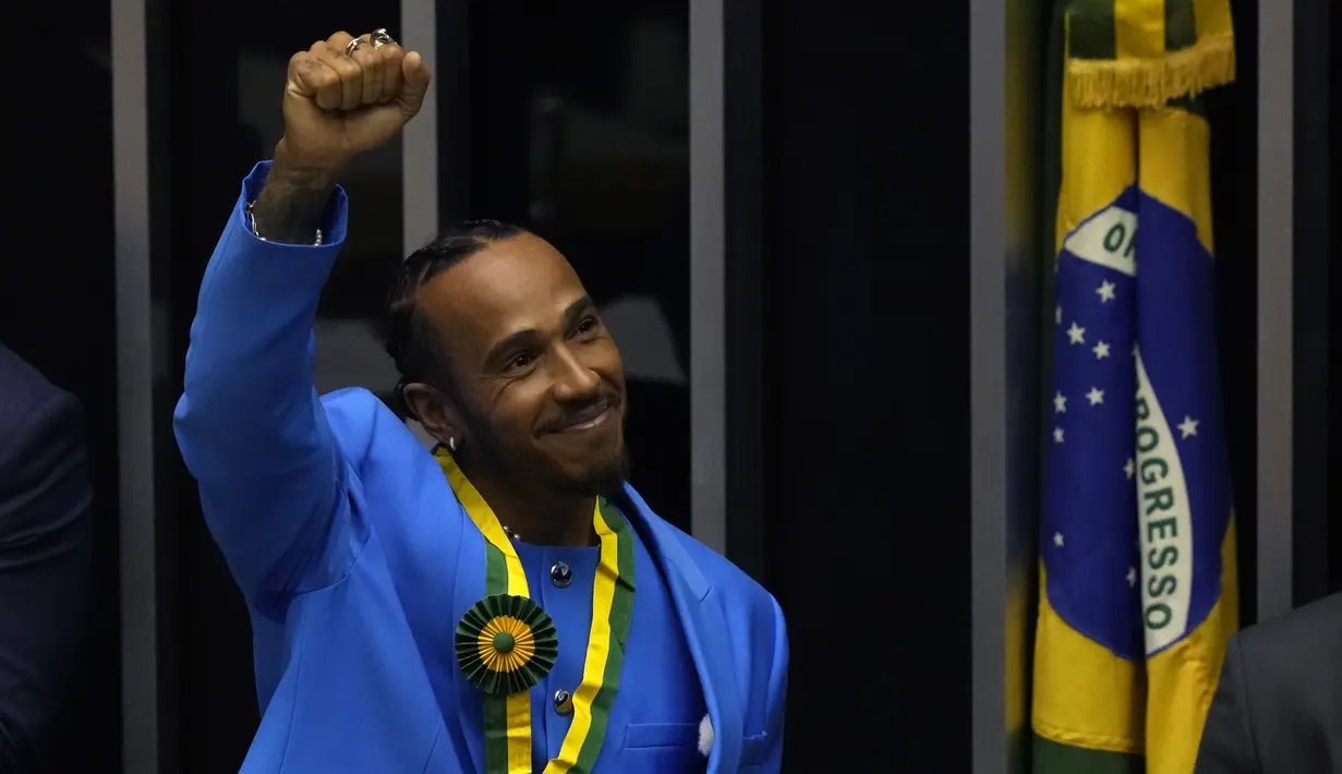 Pembalap Formula Satu Mercedes asal Inggris, Lewis Hamilton, menyapa penonton saat upacara penerimaan gelar Warga Kehormatan Brasil di Chamber of Deputies di Brasilia, Brasil (7/11/2022). (AP Photo/Eraldo Peres)