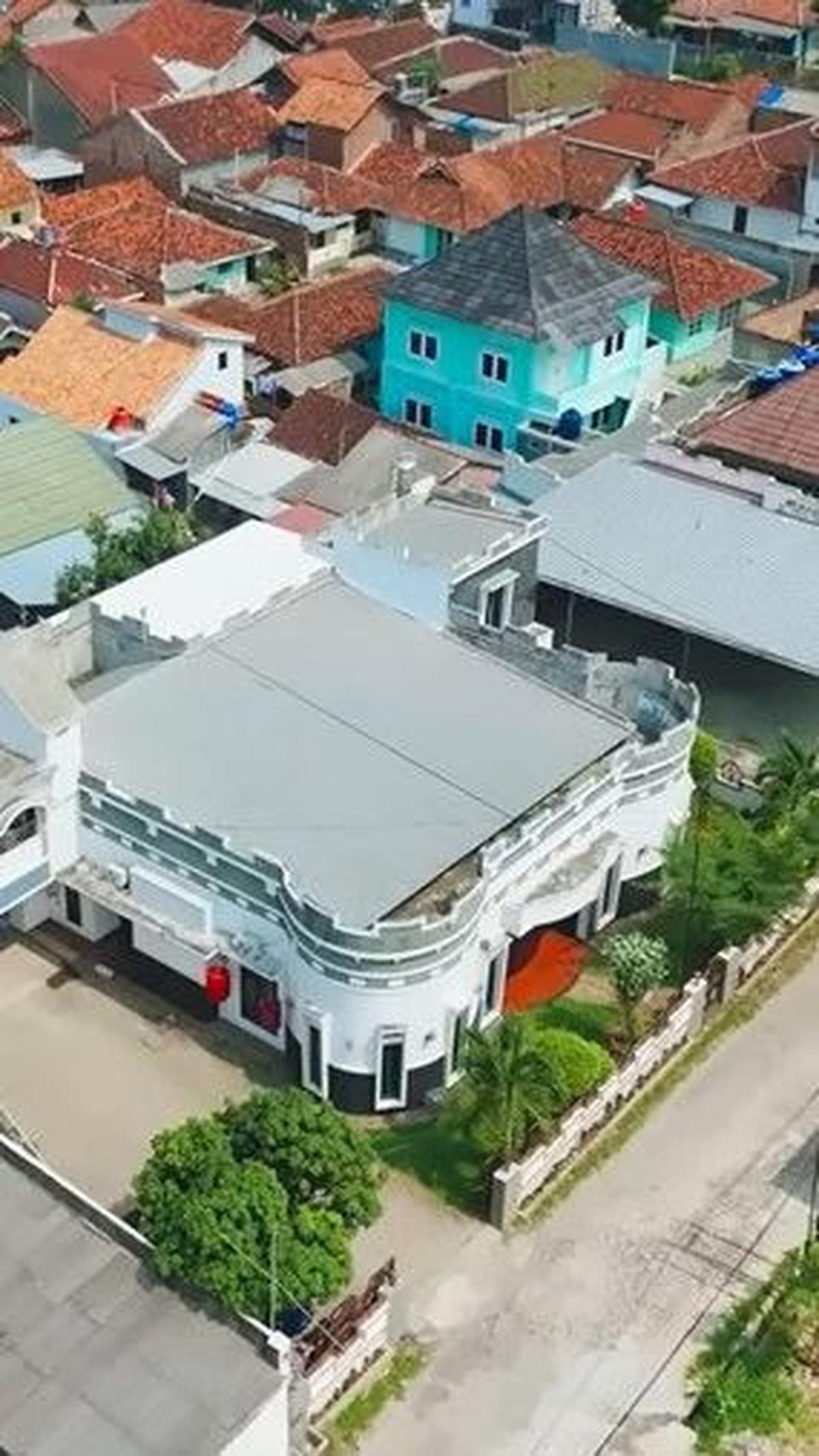 Penampakan dari udara menunjukkan desain rumah Andika yang unik dan berbeda dari rumah-rumah di sekitarnya.