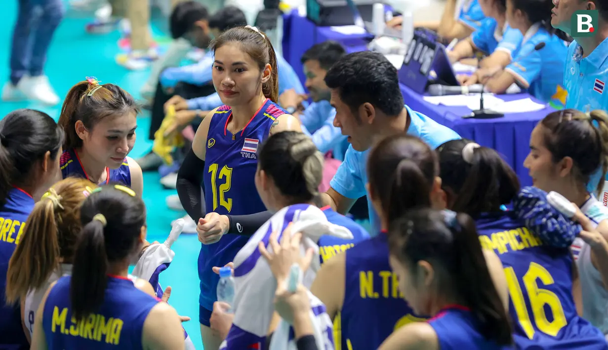 <p>Pemain Timnas Bola Voli Putri Thailand, Hattaya Bamrungsuk (tengah) mendengarkan arahan dari pelatih Sriwacharamaytakul Danai saat laga Grup A Bola Voli Putri SEA Games 2023 melawan Timnas Bola Voli Putri Indonesia di Olympic Complex Indoor Main Hall, Phnom Penh, Kamboja, Selasa (09/05/2023). (Bola.com/Abdul Aziz)</p>