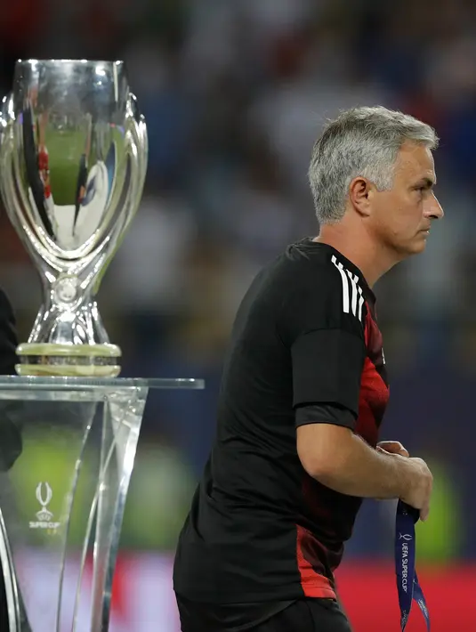Pelatih Manchester United, Jose Mourinho berjalan melewati trofi Piala Super Eropa 2017 usai timnya dikalahkan Real Madrid dalam laga final di Philip II Arena, Skopje, Macedonia, Selasa (8/8). MU takluk 1-2 dari Real Madrid. (AP Photo/Thanassis Stavrakis)