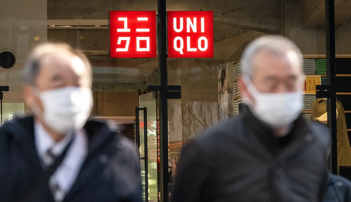 Pejalan kaki berjalan di depan toko Uniqlo yang dioperasikan oleh Fast Retailing Jepang di Tokyo, Rabu (11/1/2023). Pemilik jaringan ritel Uniqlo, Fast Retailing akan menaikkan gaji tahunan untuk karyawan mereka di Jepang hingga 40 persen. (Photo by Philip FONG / AFP)