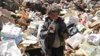 Seorang bocah laki-laki minum jus kadaluwarsa dari tumpukan sampah di sebuah tempat pembuangan akhir (TPA) di pinggiran Sanaa, Yaman, Rabu (16/11). Setiap hari para bocah di daerah itu mengumpulkan sampah untuk didaur ulang. (REUTERS/Mohamed al-Sayaghi)