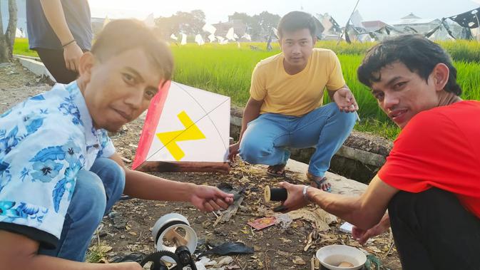 Tony, Ucok dan Ardi nampak asik berbincang, sambil mengatur berapa panjang gelasan atau benang tajam yang akan digunakan untuk adu layangan di Garut. (Liputan6.com/Jayadi Supriadin)