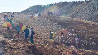 Dalam foto yang diambil Sabtu, 21 November 2015 dan dirilis oleh Eleven Media Group ini, para pekerja tambang membawa barang-barang mereka berjalan setelah rumah mereka hancur akibat tanah longsor di tambang batu giok Phakant, Negara Bagian Kachin, Myanmar.  Tanah longsor di dekat tambang batu giok di Myanmar utara menewaskan banyak orang dan menyebabkan banyak orang hilang, sebagian besar dari mereka adalah penduduk desa yang memilah-milah tumpukan besar tailing dan limbah, kata seorang tokoh masyarakat dan pengusaha pada Minggu. (Eleven Grup Media melalui AP)