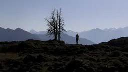 Seorang wanita menikmati pemandangan pegunungan Alpen di dekat Kitzbuehl, Austria (27/10/2019). Pegunungan Alpen adalah nama pegunungan besar di Eropa yang membentang dari Austria dan Slovenia di timur, melalui Italia, Swiss, Liechtenstein, dan Jerman sampai ke Prancis. (AP Photo/Matthias Schrader)