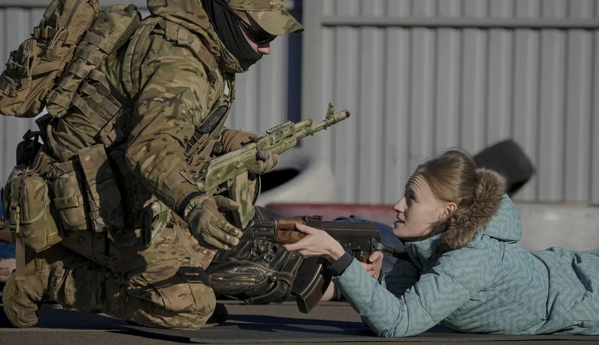 Seorang anak muda mengacungkan senjata selama latihan dasar perang untuk warga sipil, oleh Unit Pasukan Khusus Azov, dari Garda Nasional Ukraina, di Mariupol, wilayah Donetsk, Minggu (13/2/2022). Mereka disiapkan untuk bisa bertahan di tengah kekhawatiran akan invasi Rusia (AP Photo/Vadim Ghirda)