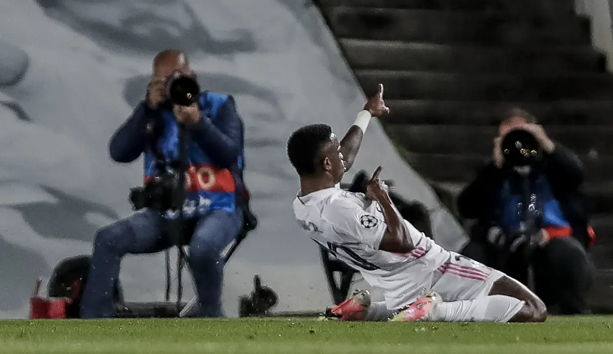 Striker Real Madrid, Vinicius Junior melakukan selebrasi usai mencetak gol pertama timnya ke gawang Liverpool dalam laga leg pertama babak perempatfinal Liga Champions 2020/2021 di Alfredo di Stefano Stadium, Selasa (6/4/2021). Real Madrid menang 3-1 atas Liverpool. (AP/Manu Fernandez)