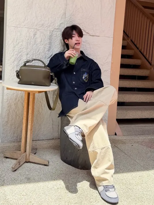 Blue Pongtiwat memiliki Dior Archie Bag yang dipadukan atasan denim serta celana beigenya. [@blue_pongtiwat]