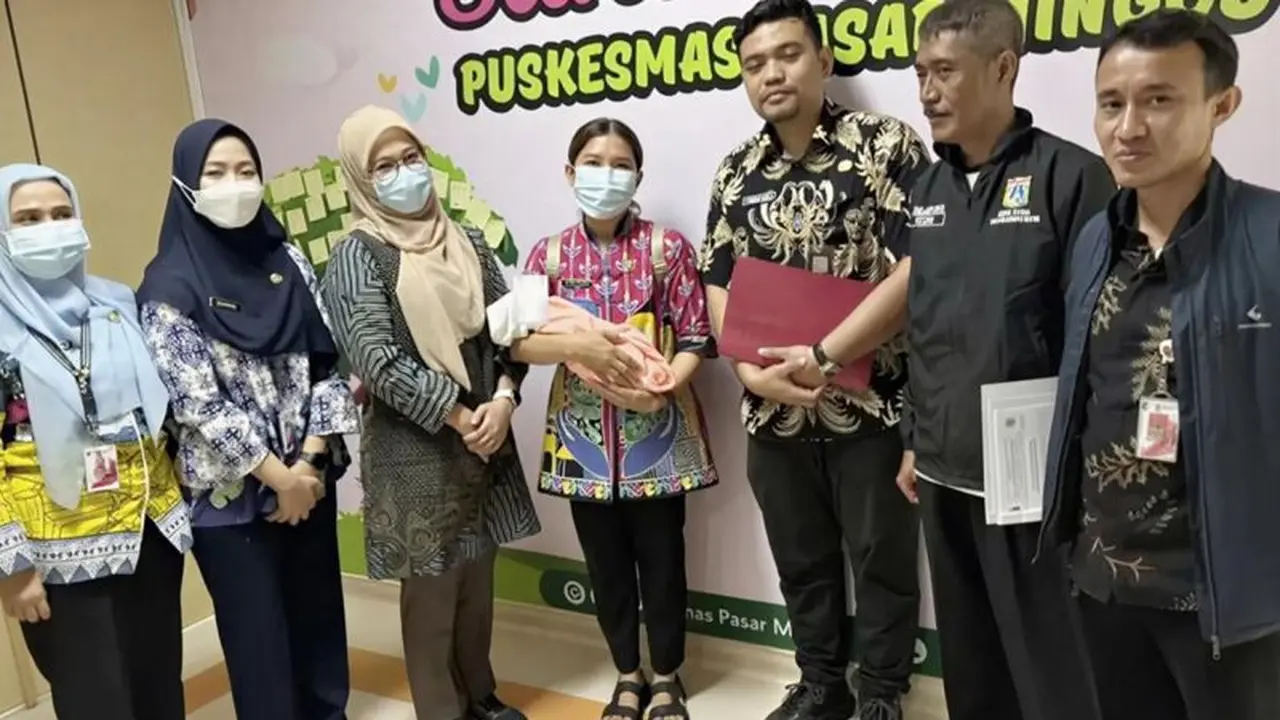 Petugas menggendong bayi laki-laki ditemukan oleh seorang guru bernama Maryono (44) yang tiba di depan SD Tarakanita I, Kebayoran Baru