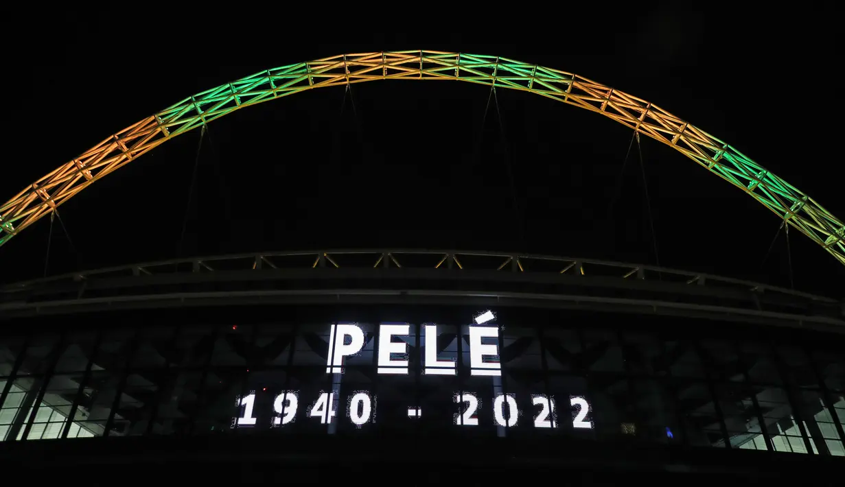 Lengkungan Stadion Wembley menyala dengan warna Brasil setelah pengumuman bahwa mantan pemain sepak bola Brasil Pele meninggal dunia, London, Inggris, 29 Desember 2022. Edson Arantes do Nascimento atau yang dikenal sebagai Pele, raja sepak bola Brasil yang menang rekor tiga Piala Dunia dan menjadi salah satu tokoh olahraga paling berwibawa abad lalu, meninggal pada usai 82 tahun di di Sao Paulo. (Kieran Cleeves/PA via AP)